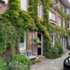 Afbeelding van een huis met een groene gevel, een klimop.