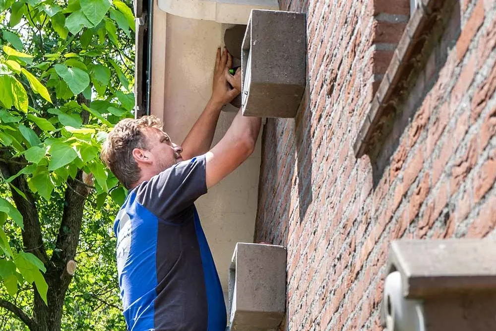 Vivara_Pro_Plaatsing Afbeelding van een medewerker van vivara Pro die een nestkast voor de huiszwaluw aan het plaatsen is